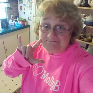 Molly B Foundation supporter wearing pink hoodie with logo.