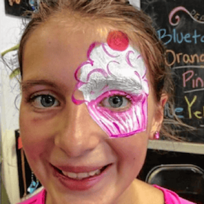 Molly with face painted cupcake and a big smile
